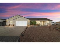 Charming single-story home with a two-car garage, desert landscaping, and covered front porch at 5950 Mojave St, Pahrump, NV 89061