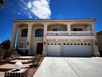 Two-story home featuring arched columns, a second story balcony, and a spacious three car garage at 6571 Abalone Shell Ct, Las Vegas, NV 89139