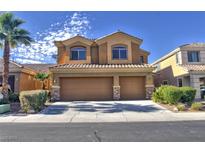 Two-story home featuring a two-car garage, desert landscaping and a tile roof at 72 Broken Putter Way, Las Vegas, NV 89148