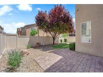 Private backyard with a patio, rock landscaping, and beautiful tree at 8562 Burning Bridge Ct, Las Vegas, NV 89131