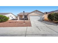 Charming single-story home featuring a two-car garage and desert landscaping for easy maintenance at 905 Harp Way, North Las Vegas, NV 89032