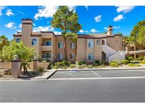 Attractive condo building featuring stucco facade and mature landscaping, under a bright blue sky at 9325 W Desert Inn Rd # 104, Las Vegas, NV 89117