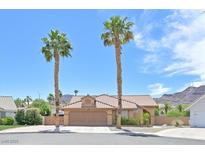 Charming single-story home with a well-manicured lawn and two tall palm trees in the front yard at 100 Crossfoot Terrace Ct, Henderson, NV 89002