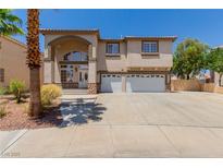 Two-story home featuring stucco siding, desert landscaping, an arched entryway, and a three-car garage at 1054 Broomfield Dr, Henderson, NV 89074