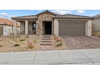 Beautiful single-story home featuring a stone facade, manicured landscaping, and a two-car garage at 10863 Gardenova Ave, Las Vegas, NV 89166