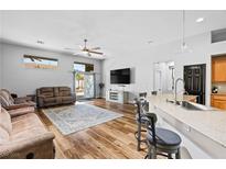 Inviting living room features an open floor plan, wood floors, neutral tones, and sliding door access to the outdoors at 4212 Helens Pouroff Ave, North Las Vegas, NV 89085