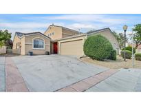 Charming single-story home featuring a two-car garage, red front door, and well-maintained landscaping at 4708 Cohiba Way, North Las Vegas, NV 89031