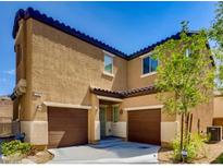 Charming stucco home showcasing two-car garage, complemented by a small tree and well-maintained landscaping at 7760 Trends Ct, Las Vegas, NV 89149