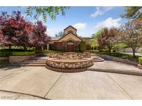 Stately home showcasing a tiered fountain, lush landscaping, and a brick facade at 112 Quail Run Rd, Henderson, NV 89014