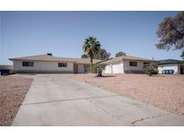 Charming single-story home with an expansive driveway and a well-manicured desert landscape at 2755 E Russell Rd, Las Vegas, NV 89120