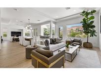 Bright, open living room with modern furnishings, hardwood floors, and mountain views from the large windows at 2797 Turtle Head Peak Dr, Las Vegas, NV 89135
