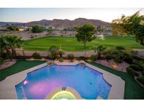 Inviting pool and spa overlook lush backyard and golf course with mountain views at 2837 Turtle Head Peak Dr, Las Vegas, NV 89135