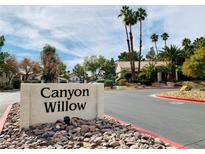 Inviting community entrance with 'Canyon Willow' sign, complemented by well-manicured landscaping and mature palm trees at 3055 Key Largo Dr # 204, Las Vegas, NV 89120