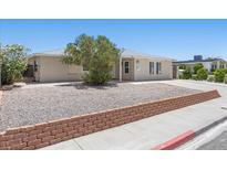 Charming single-story home features low-maintenance landscaping and a brick-lined flower bed at 321 Oil Lantern Ln, Las Vegas, NV 89145