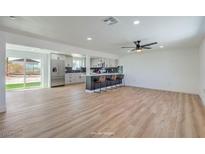 Open-concept living room flows into kitchen featuring a large island with bar seating and stainless steel appliances at 5200 Blanton Dr, Las Vegas, NV 89122