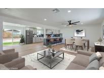 Open-concept living area with a modern kitchen, dining space, and a sliding glass door to the backyard at 5200 Blanton Dr, Las Vegas, NV 89122