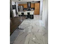 Bright kitchen featuring an island with bar seating and stainless steel appliances at 6208 Mandarin Dr, Las Vegas, NV 89108