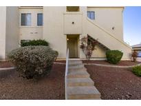 Inviting condo exterior featuring landscaped grounds and a private entrance with steps at 698 S Racetrack Rd # 711, Henderson, NV 89015