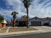 Charming single-story home with a two-car garage, desert landscaping, and tile roof at 715 Heritage Point Dr, Henderson, NV 89002