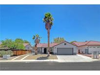 Charming single-story home featuring a 2-car garage, tile roof, desert landscaping, and mature palm trees at 715 Heritage Point Dr, Henderson, NV 89002