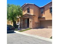 A well-maintained two-story home showcases an attached two-car garage and a charming, stone-accented entrance at 7160 Mineral Park Ave, Las Vegas, NV 89179