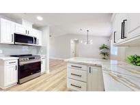 Beautiful kitchen features white cabinets, stainless steel appliances, and an island with quartz countertops at 744 Hubbard St, Las Vegas, NV 89110