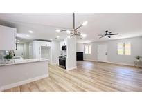 Bright living room featuring an open floor plan with modern lighting and sleek wood-look floors at 744 Hubbard St, Las Vegas, NV 89110