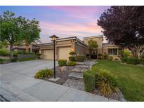 Beautiful single-story home with a three-car garage, manicured lawn, and stone walkway leading to the front door at 1016 Sable Mist Ct, Las Vegas, NV 89144