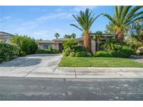 Charming single story home with lush landscaping, mature palm trees, and a spacious driveway at 10320 Luxembourg Ave, Las Vegas, NV 89145