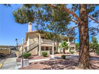 Inviting condo complex featuring well-maintained landscaping and convenient staircase access at 1201 N Buffalo Dr # 202, Las Vegas, NV 89128