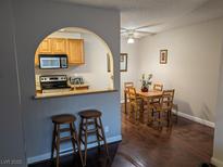 Bright dining area with dark wood floors adjacent to an open kitchen featuring stainless steel appliances at 1515 E Reno Ave # C207, Las Vegas, NV 89119