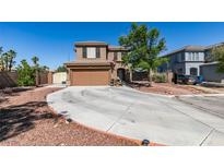 Two-story home features a circular driveway, two-car garage and desert landscaping at 4512 Long Horse Ct, Las Vegas, NV 89147