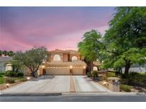 Stunning home featuring manicured landscaping, a spacious driveway, and a three-car garage against a beautiful twilight sky at 5225 Sandy Cactus Ln, Las Vegas, NV 89149