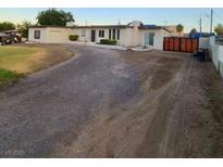 A single story home with a dirt driveway, a well-manicured lawn, and a brown wooden fence at 5617 Alfred Dr, Las Vegas, NV 89108