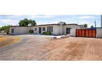 Charming single-story home with a long driveway and a modern orange-and-black gate at 5617 Alfred Dr, Las Vegas, NV 89108