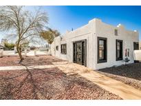 Charming home featuring a white exterior with black trim, surrounded by decorative stone at 603 W Adams Ave, Las Vegas, NV 89106