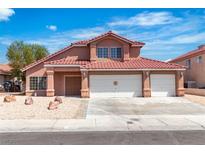 Charming two-story home with a three car garage and a low maintenance front yard with desert landscaping at 7720 Leavorite Dr, Las Vegas, NV 89128