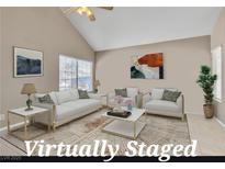 Bright living room featuring neutral walls, vaulted ceilings, and large windows allowing natural light at 7720 Leavorite Dr, Las Vegas, NV 89128