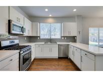 Bright kitchen with white cabinets, stainless steel appliances, and a modern backsplash at 1013 Corsica Ln, Las Vegas, NV 89144