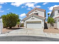 Charming stucco home with a two-car garage, landscaped yard, and a terracotta roof at 3632 Julia Waldene Ct, Las Vegas, NV 89129