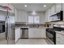 Well-lit kitchen with stainless steel appliances, granite countertops, and mosaic tile backsplash at 368 Umbria Way, Henderson, NV 89014
