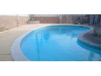 Large in-ground pool with blue water, concrete patio and landscaping surrounding the property at 5178 Wilbur St, Las Vegas, NV 89119