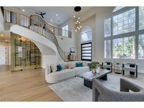 Bright living room features soaring ceilings, staircase, and expansive windows offering abundant natural light at 5573 San Florentine Ave, Las Vegas, NV 89141
