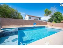 Backyard pool with a basketball hoop and an adjacent house behind a wall at 5600 Old Stable Ave, Las Vegas, NV 89131