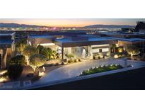 Striking modern home with sleek architecture and a well-manicured front yard, offering captivating city views at sunset at 671 Scenic Rim Dr, Henderson, NV 89012