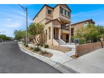 Two-story home with stucco exterior, wrought iron railing, and low maintenance landscaped yard at 8949 Merry Mullion Ct, Las Vegas, NV 89149