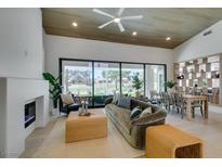 Bright living room with fireplace, modern decor, and large windows overlooking a golf course at 9425 Villa Ridge Dr, Las Vegas, NV 89134