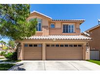 Charming two-story home with a three-car garage and desert landscaping against a clear blue sky at 9440 Grenville Ave, Las Vegas, NV 89134