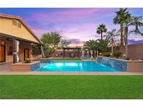 Beautiful backyard pool with lush landscaping and covered patio, perfect for outdoor entertaining at 9685 Stonily Ln, Las Vegas, NV 89178