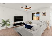 Bright living room with a ceiling fan, neutral walls, wood-look floors, and a large sectional sofa at 9743 Mojave Mountain St, Las Vegas, NV 89166